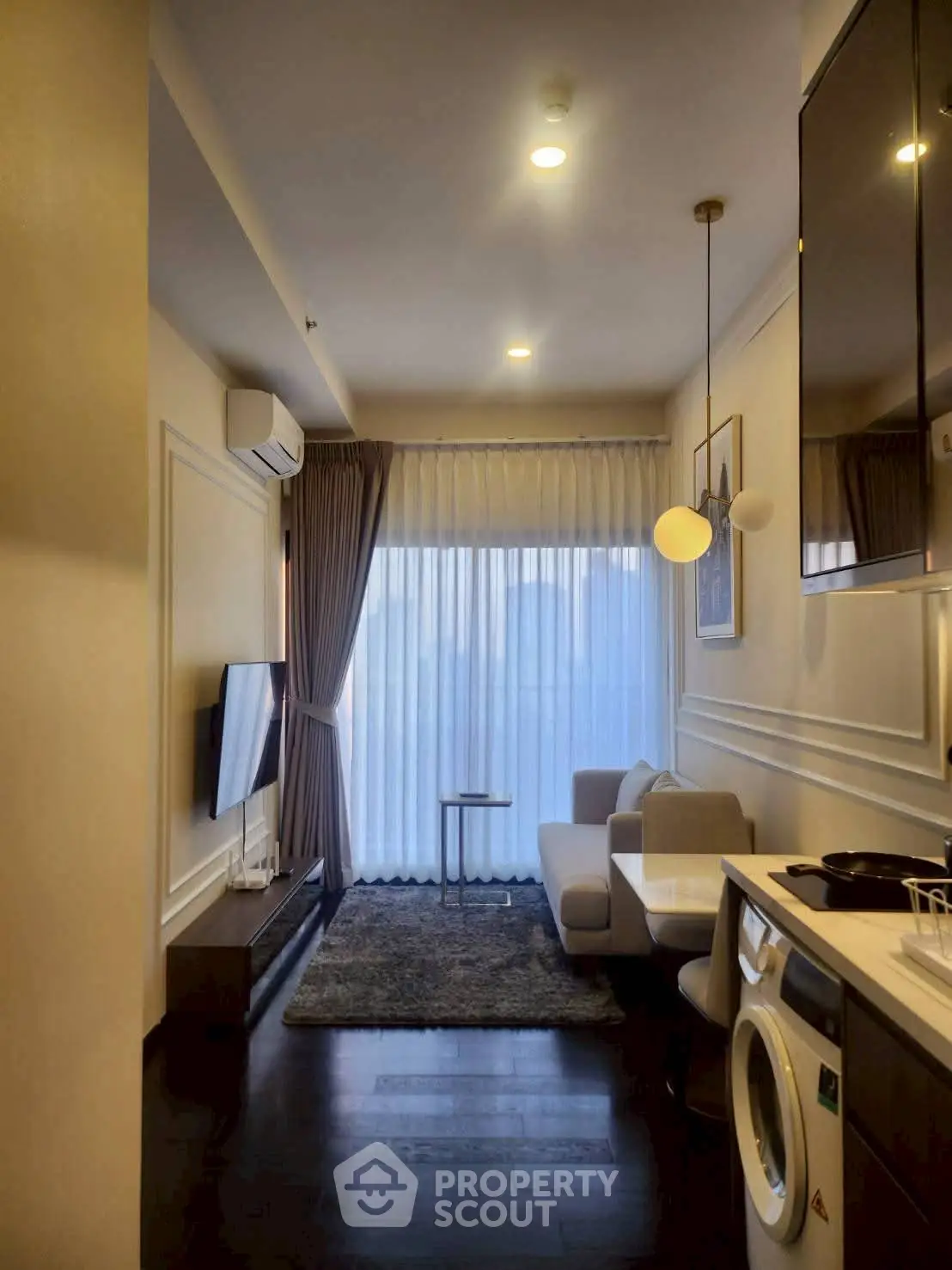 Modern living room with sleek furniture and washing machine, ideal for urban living.