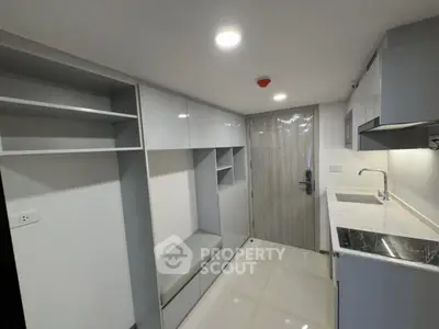 Modern compact kitchen with sleek cabinetry and integrated appliances
