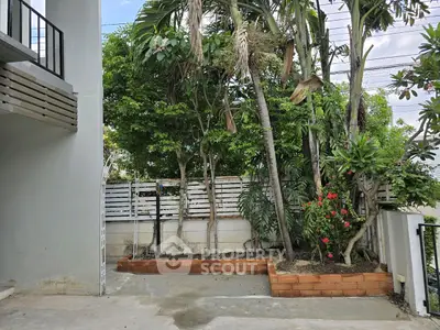 Charming garden area with lush greenery and brick planters in a modern residential setting.