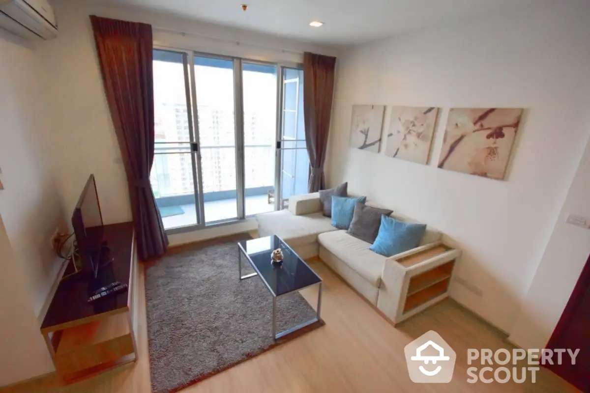 Modern living room with large windows and balcony access in a stylish apartment.