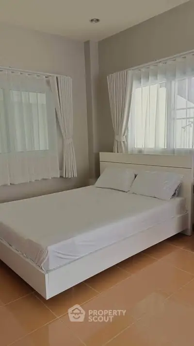 Bright and airy bedroom with modern minimalist design and large windows.