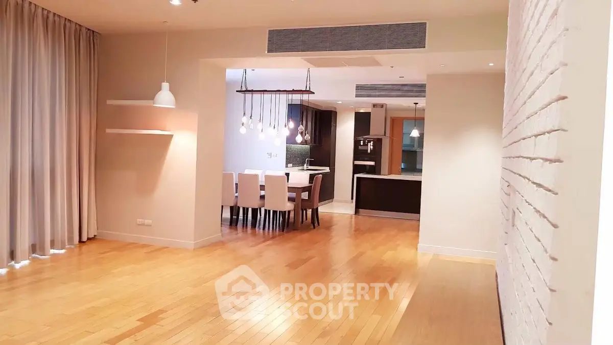 Spacious open-plan living and dining area with modern kitchen and hardwood floors.