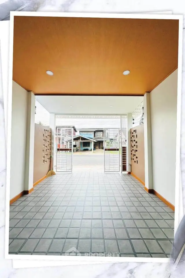 Spacious entrance with tiled flooring and modern gate design, perfect for welcoming guests.