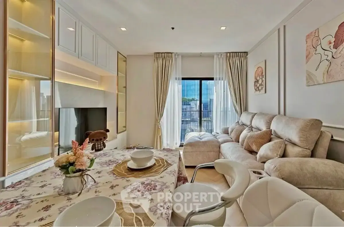 Luxurious living room with plush seating and elegant decor, featuring a large window with city view.