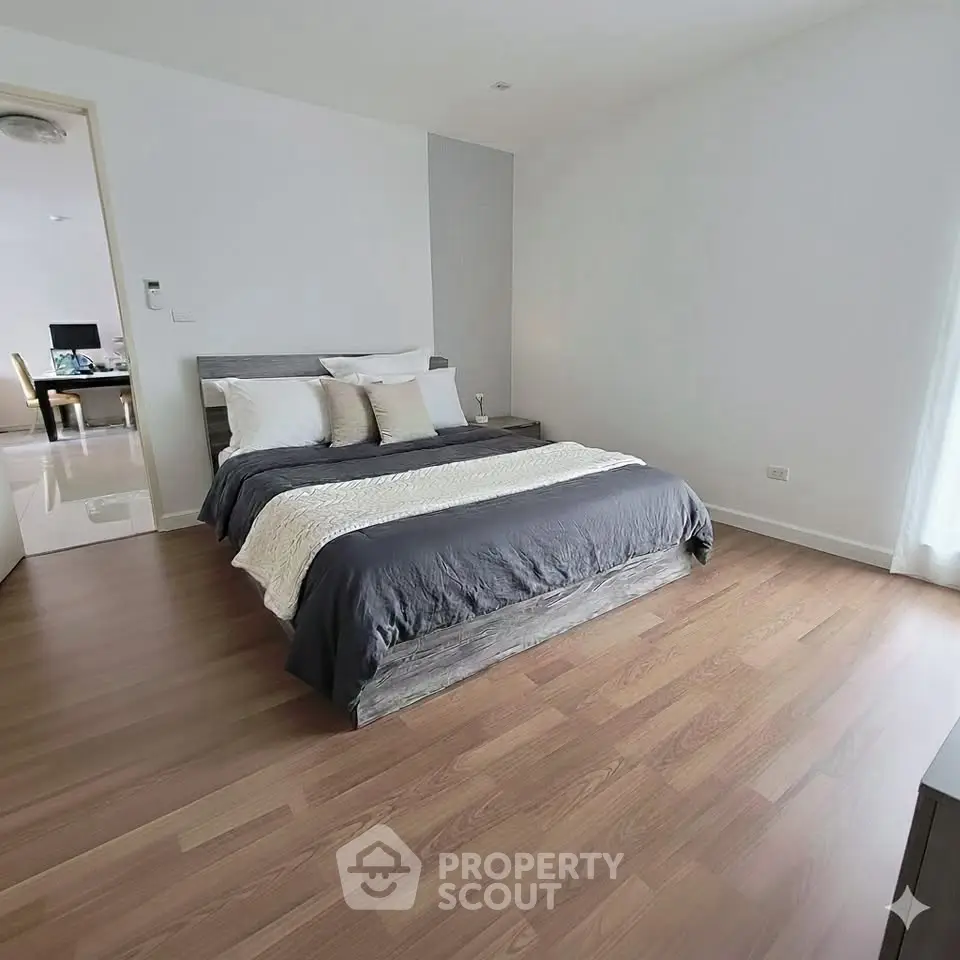 Spacious modern bedroom with wooden flooring and elegant decor