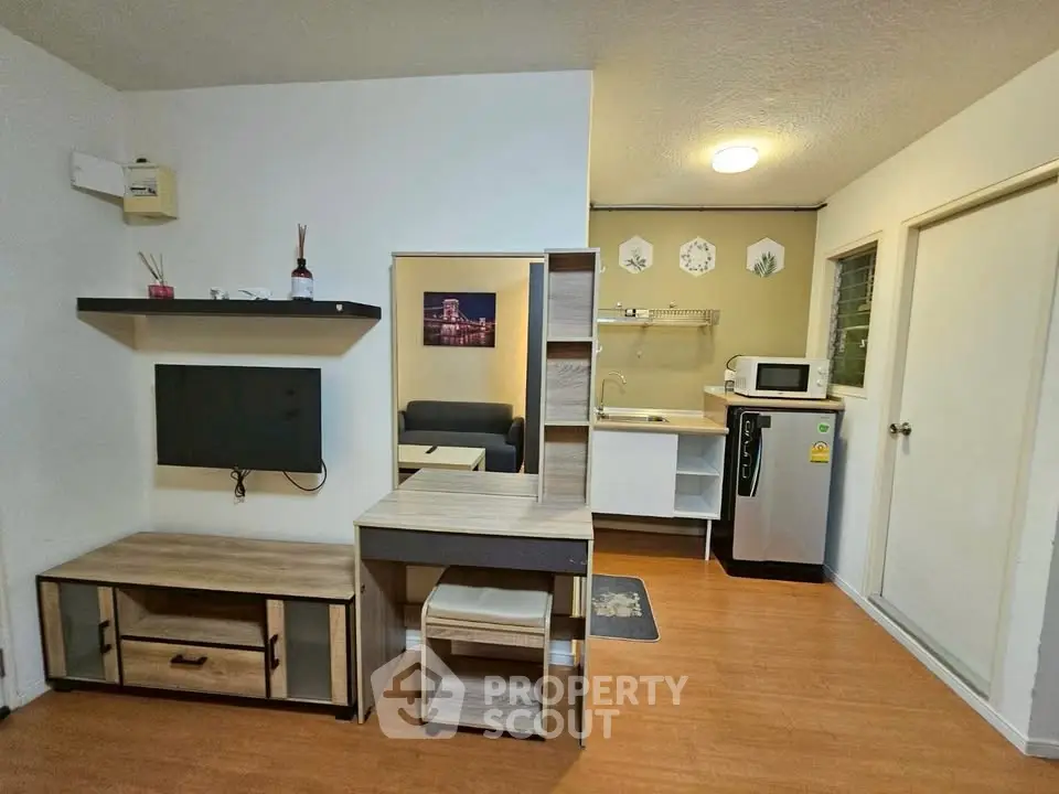 Modern studio apartment with open kitchen and stylish living area, featuring wooden flooring and contemporary decor.