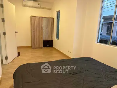 Cozy bedroom with wooden flooring and modern wardrobe in a bright apartment.