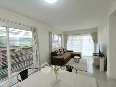 Spacious living room with modern decor and large windows for natural light.