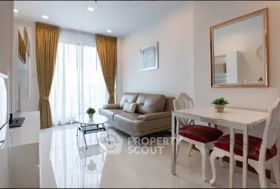 Elegant living room with modern decor, cozy sofa, and dining area in a bright apartment.