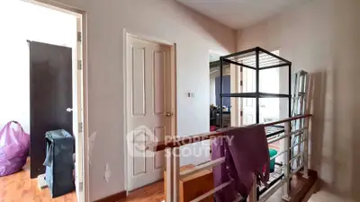 Spacious hallway with wooden flooring and modern railing in a residential property