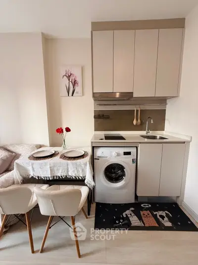Chic compact kitchen with washing machine and dining area, perfect for modern living.