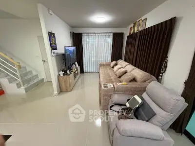 Spacious living room with modern furniture and natural light, perfect for relaxation and entertainment.