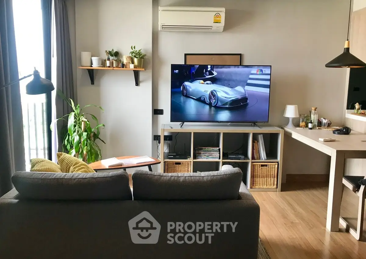 Modern living room with sleek furniture and large TV, perfect for relaxation and entertainment.