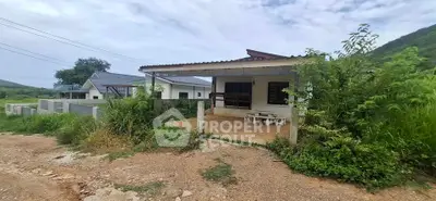 Charming countryside house with spacious front patio and lush greenery, perfect for serene living.