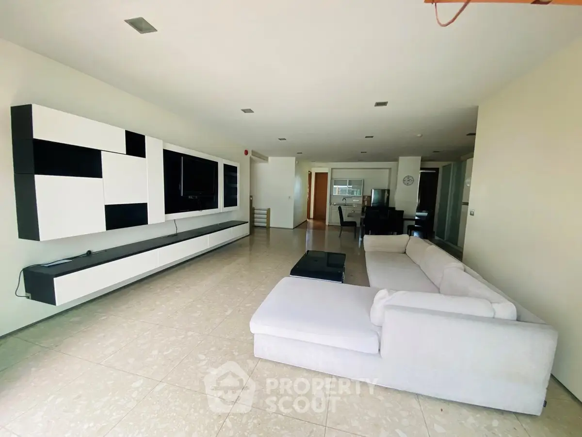 Spacious modern living room with sleek furniture and open layout, perfect for entertaining.
