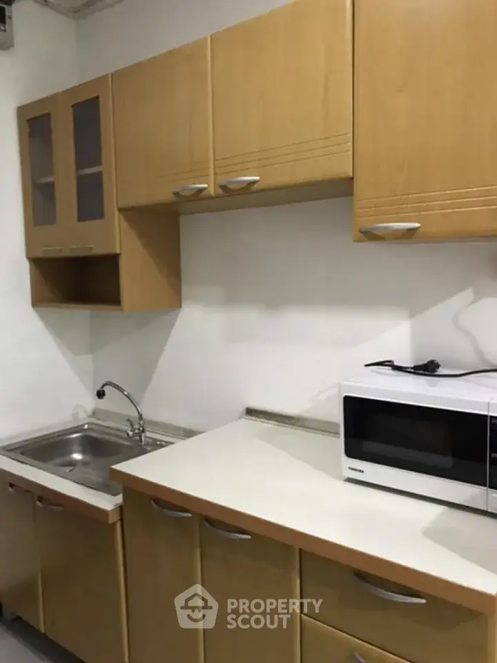 Compact kitchen with wooden cabinets and modern appliances