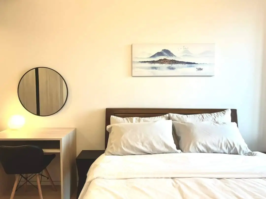 Cozy bedroom with modern decor and a serene mountain painting above the bed.