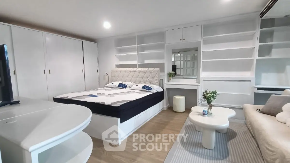 Spacious modern bedroom with built-in shelves and elegant decor
