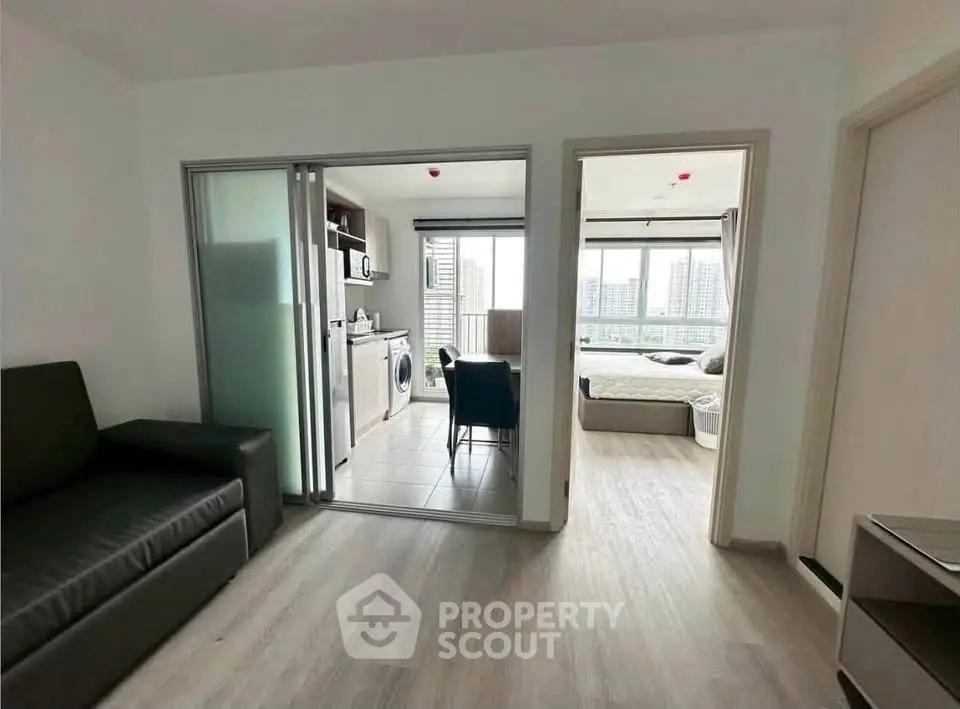 Modern apartment interior with open layout, featuring a cozy living area, kitchen, and bedroom with city view.