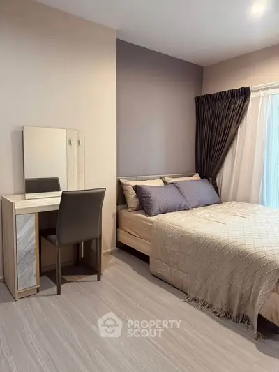Modern bedroom with stylish decor and natural light, featuring a cozy bed and elegant vanity set.
