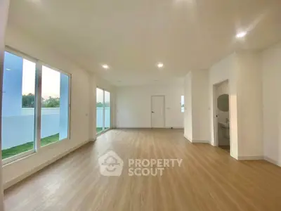 Spacious modern living room with large windows and wooden flooring