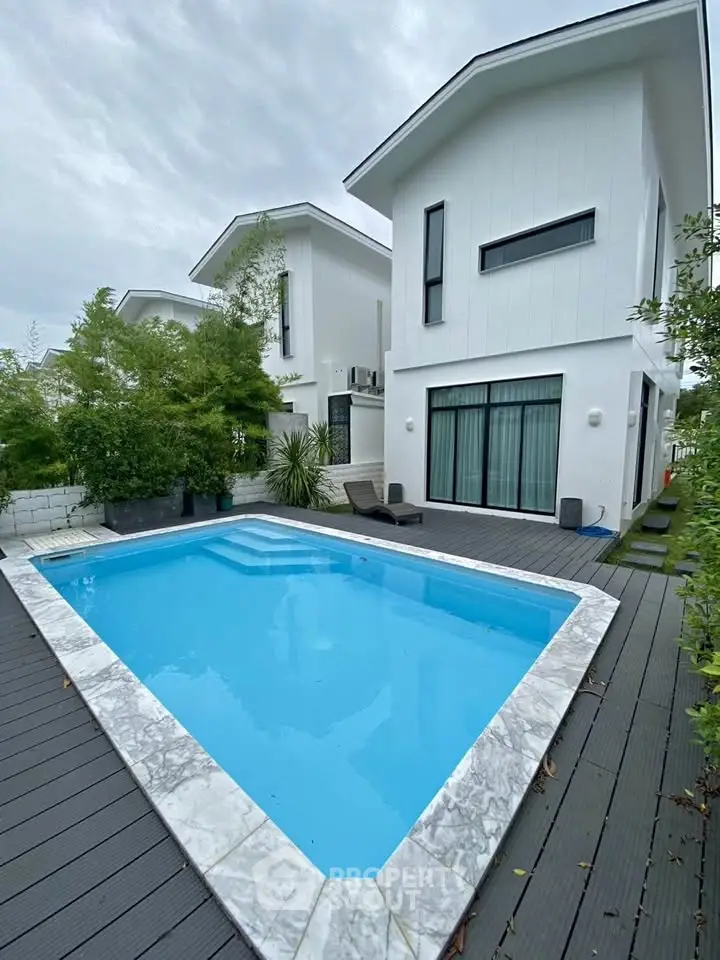 Modern white house with private pool and lush greenery