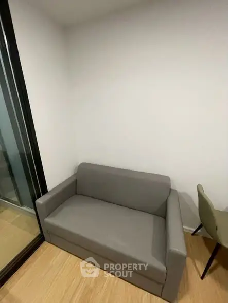 Modern compact living room with sleek gray sofa and wooden flooring