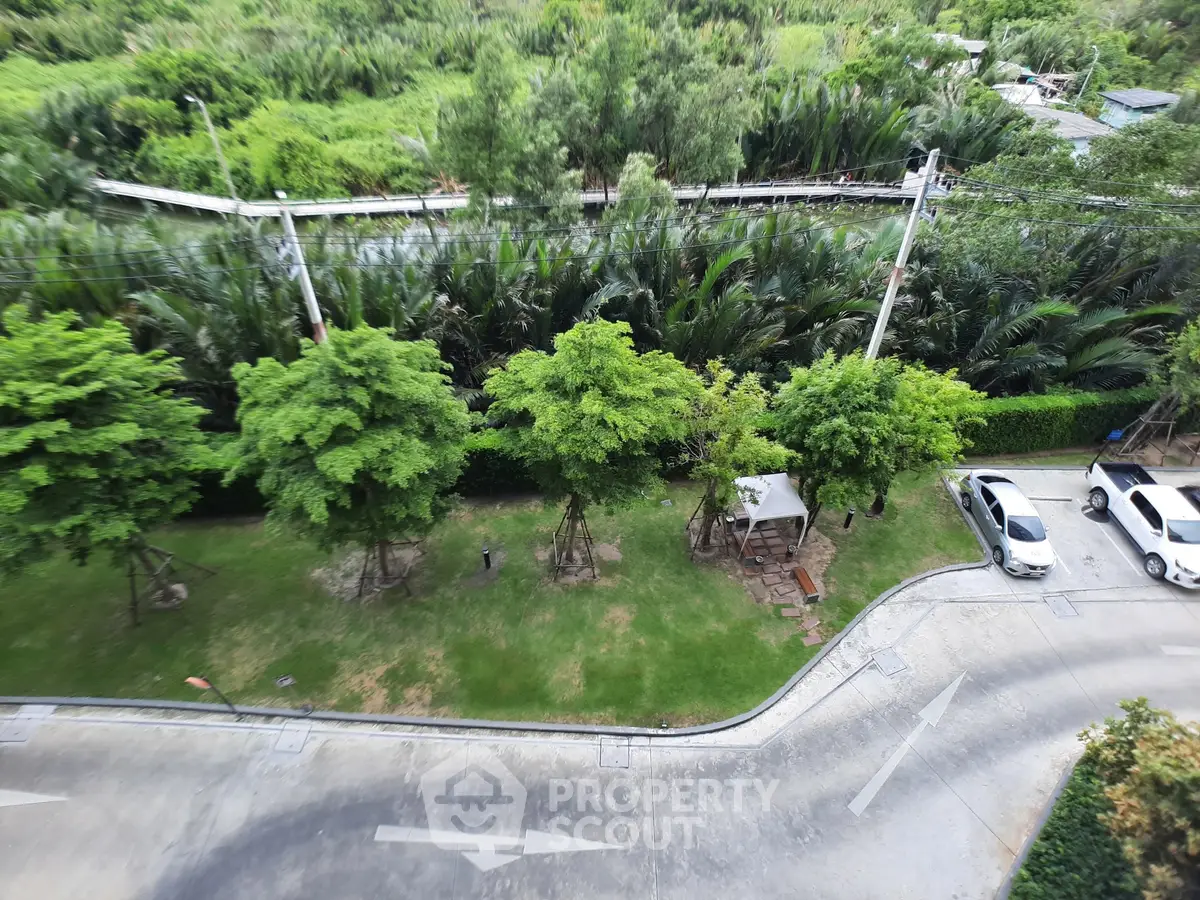 Scenic view of lush greenery and parking area from a high vantage point, showcasing serene outdoor surroundings.