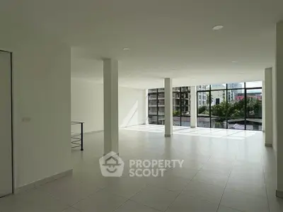 Spacious open-plan living area with large windows and city view.