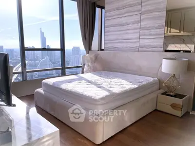 Luxurious bedroom with stunning city view and elegant decor in high-rise apartment.