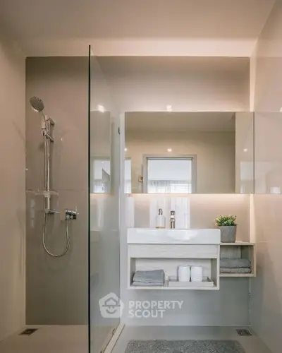 Modern bathroom with sleek shower and elegant vanity in contemporary home.