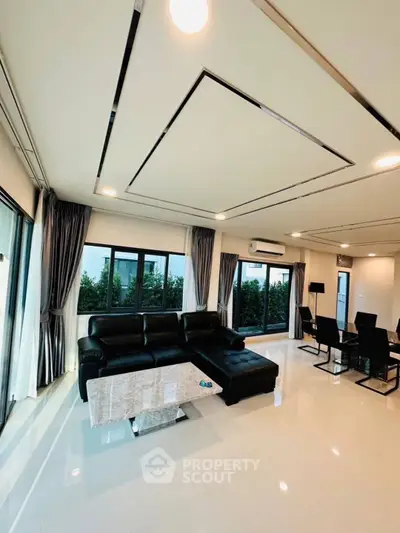 Luxurious modern living room with sleek black furniture and large windows offering garden views.