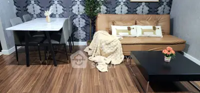 Stylish living room with modern decor, featuring a cozy sofa, elegant dining table, and chic wooden flooring.