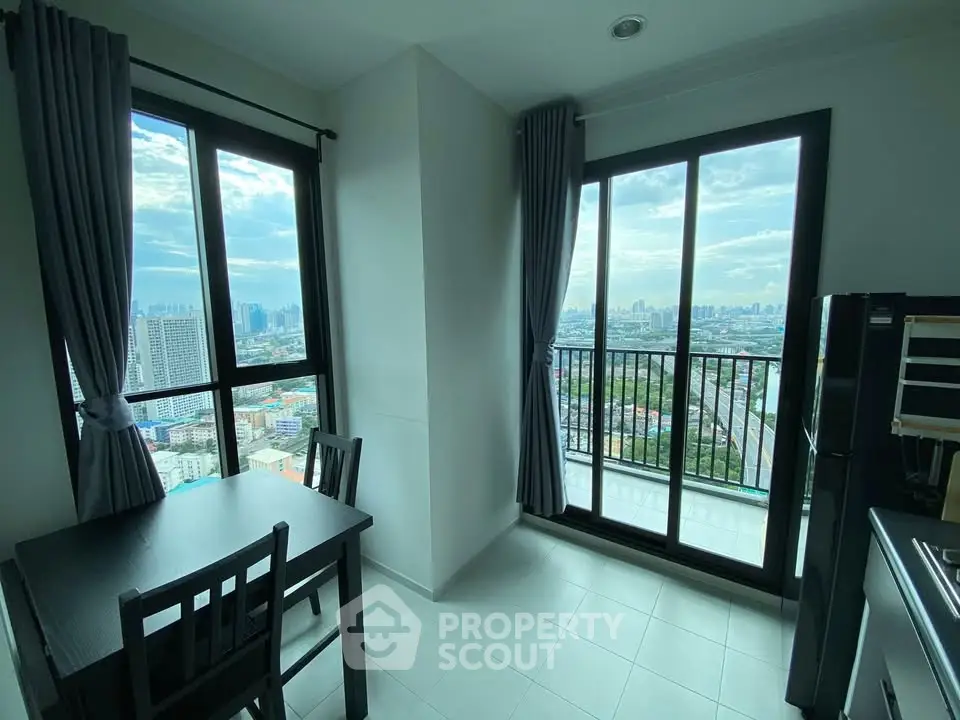 Modern apartment with stunning city view from large windows and balcony, featuring sleek dining area.