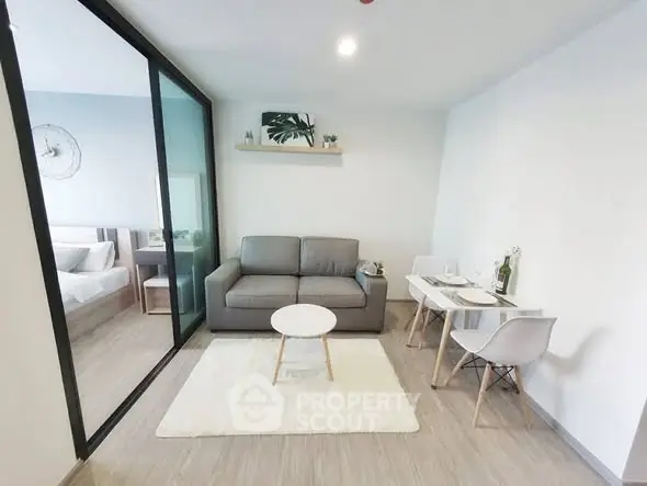 Modern living room with cozy sofa and dining area in open layout apartment.