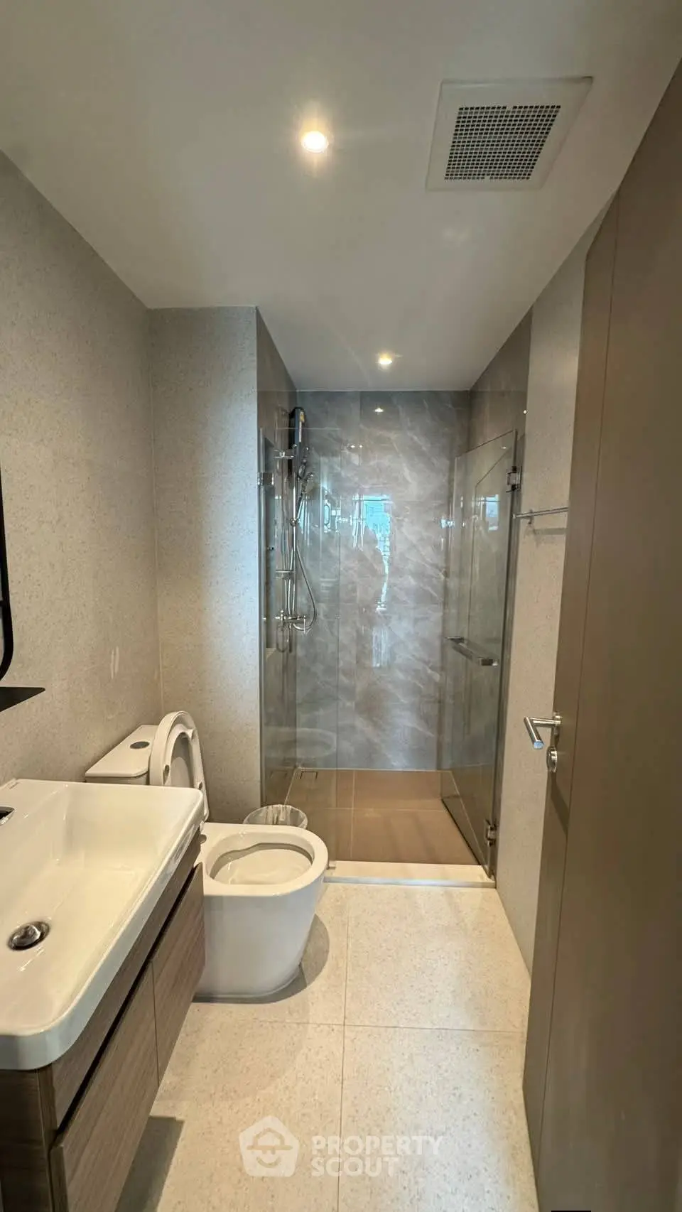 Modern bathroom with sleek design, featuring a glass shower enclosure and contemporary fixtures.