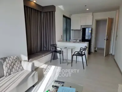 Modern living room with open kitchen and stylish furniture in a bright apartment.
