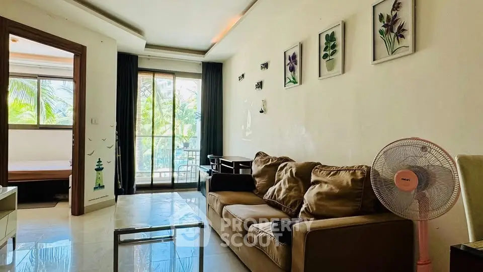 Spacious living room with modern decor and balcony view, perfect for relaxation and entertaining.