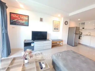 Modern living room with sleek kitchen, stylish decor, and natural light.