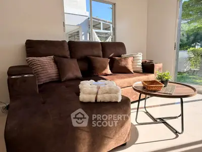 Cozy living room with plush brown sofa and modern coffee table, bathed in natural light.