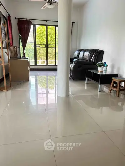 Spacious living room with large windows and modern furniture, perfect for relaxation and entertainment.