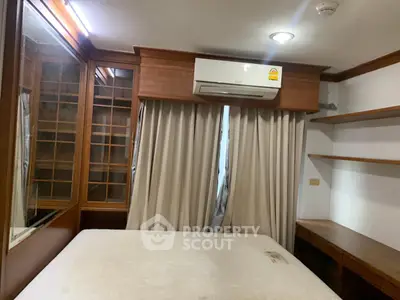 Cozy bedroom with built-in wooden shelves and air conditioning unit