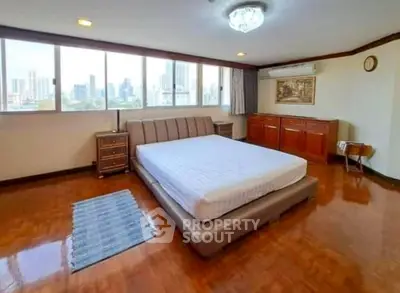 Spacious bedroom with city view and elegant wooden flooring