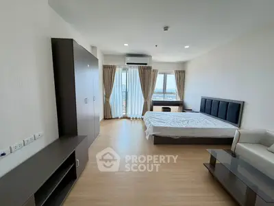 Spacious modern bedroom with large windows and wooden flooring, offering a bright and airy ambiance.