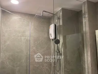 Modern bathroom with sleek shower fixtures and elegant marble tiles.