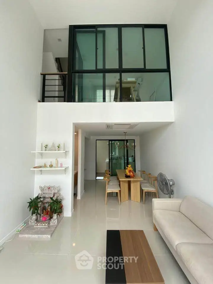 Modern duplex living room with high ceilings and stylish dining area