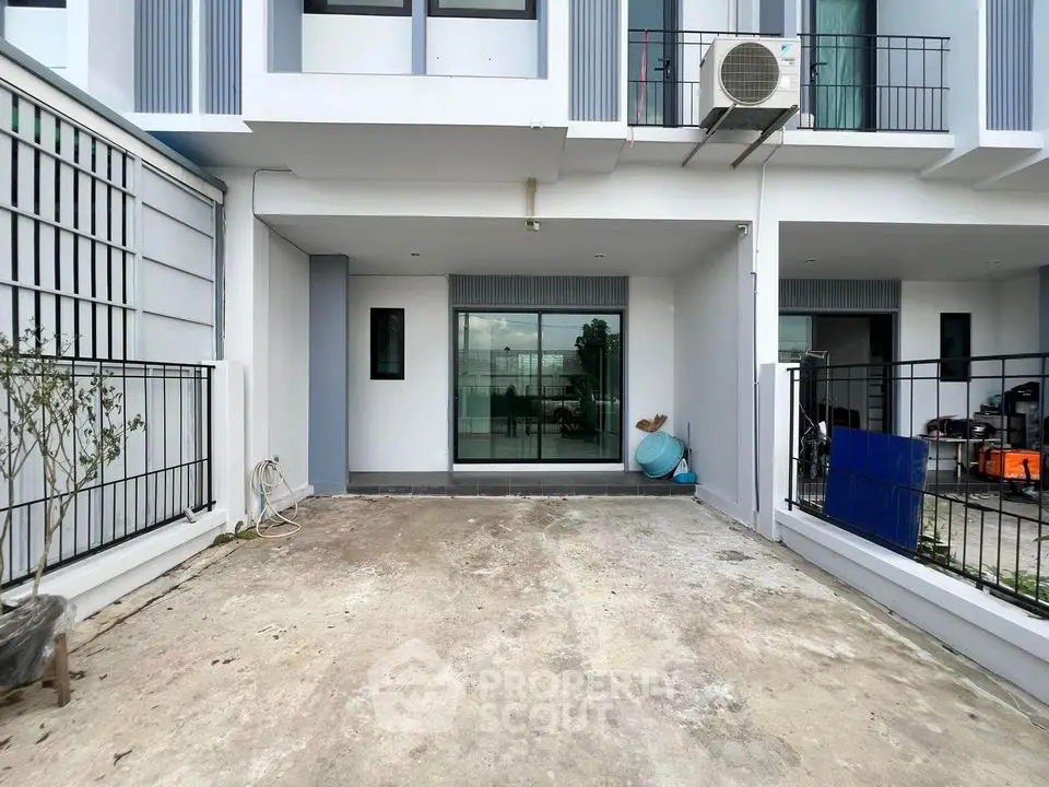 Modern townhouse exterior with spacious driveway and balcony
