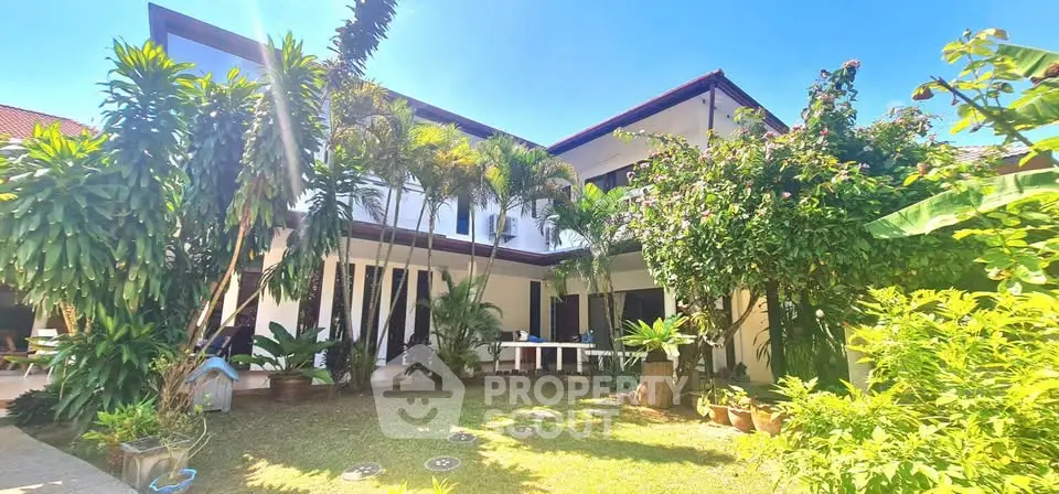 Stunning two-story home with lush garden and tropical landscaping