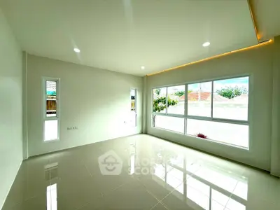 Spacious and bright living room with large windows and glossy tiled floor, perfect for modern living.