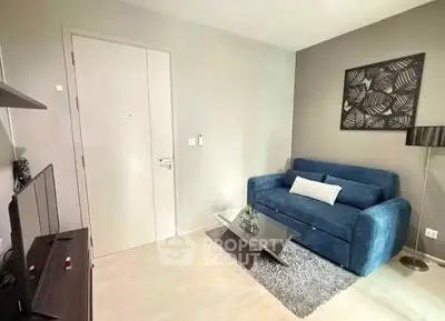 Modern living room with blue sofa and stylish decor in a cozy apartment.
